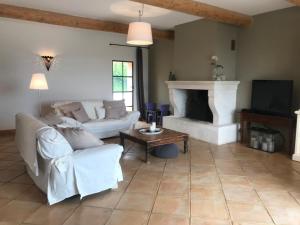 a living room with a couch and a fireplace at Maison Roquebeauresse in Pougnadoresse