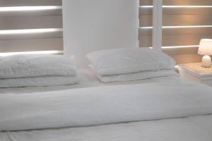 a bed with white sheets and pillows in a bedroom at A2J Luxury 1BR Balcony Venice Suite Near Malls in Manila