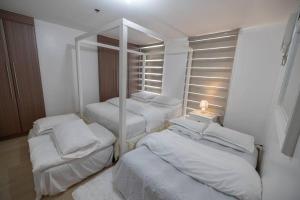 a room with three beds and a mirror at A2J Luxury 1BR Balcony Venice Suite Near Malls in Manila