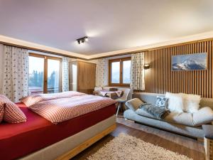 ein Schlafzimmer mit einem Bett und einem Sofa in der Unterkunft Ferienhaus Rauter in Oberndorf in Tirol