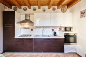 a kitchen with wooden cabinets and a sink at Villa Navagero Erizzo - Ca' Rocchetto 2 in Rovarè