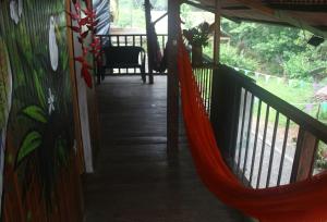 a hammock on the porch of a house at Posada Kevelin in Termales - agua caliente - nuqui +11 photos