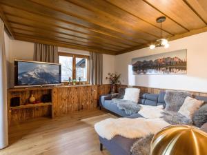 ein Wohnzimmer mit einem Sofa und einem TV in der Unterkunft Ferienhaus Rauter in Oberndorf in Tirol