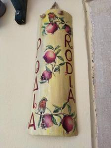um sinal na parede com maçãs em Rodia em Kynopiástai