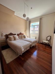 sypialnia z dużym łóżkiem i drewnianą podłogą w obiekcie Haizea w mieście Bakio