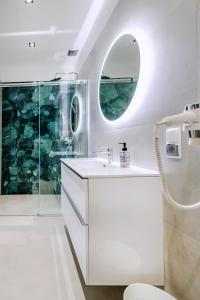 a white bathroom with a shower and a sink at Kashubian Resort in Władysławowo