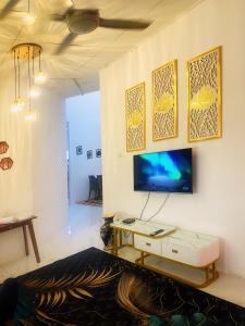 a living room with a tv on a wall at LH Homestay Bandar Utama Gua Musang in Gua Musang