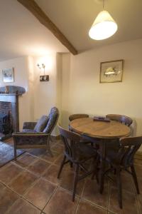 - un salon avec une table et des chaises en bois dans l'établissement Rose Bank Cottage Coniston, à Coniston