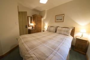 a bedroom with a large bed and two night stands at Rose Bank Cottage Coniston in Coniston
