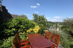 une table en bois et quatre chaises sur la terrasse dans l'établissement Rose Bank Cottage Coniston, à Coniston