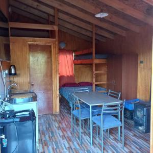 Habitación con mesa y litera en Cabañas Piukewen, en Riñinahue