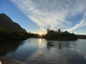 a river with the sun reflecting on the water at Cabañas Piukewen in Riñinahue