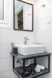 a bathroom with a white sink and a mirror at P&K LUXURY APARTMENTS 1 in Kalamata