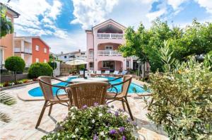 a patio with chairs and a table in front of a house at Apartman Naomi in Krk