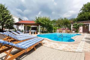a swimming pool with lounge chairs next to a building at Apartman Naomi in Krk