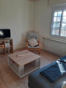 a living room with a coffee table and a chair at Coquet appartement 6 personnes avec jardin in Wintzenheim