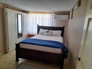 a bedroom with a large bed with a blue blanket at Cays Inn Apartments in Ribishi