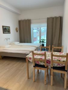 a bedroom with two beds and a table and chairs at Flygeln in Leksand