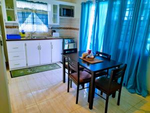 a kitchen with a table and chairs in a kitchen at Cays Inn Apartments in Ribishi