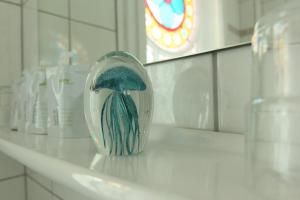 a vase sitting on a counter in a bathroom at Hotel Villa WellenRausch in Travemünde +186 photos