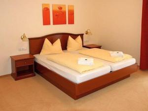 ein Schlafzimmer mit einem Bett mit zwei Nachttischen und einem sidx sidx sidx in der Unterkunft Hotelpark Bodetal mit Ferienwohnungen in Thale