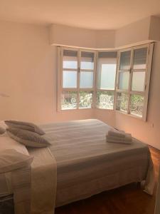 1 dormitorio con 2 camas y 2 ventanas en Estancia Nueva Córdoba en Córdoba