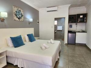 a bedroom with a large white bed with blue pillows at Hippo Lodge Apartments in St Lucia
