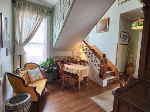 a living room with a table and chairs and a staircase at The Fresh Coast Inn at Ludington in Ludington
