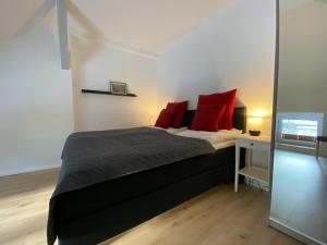 ein Schlafzimmer mit einem Bett mit roten Kissen in der Unterkunft Ferienhaus Bimmelbahn in Olbersdorf