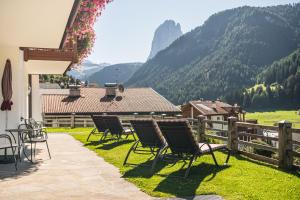 a group of chairs on a patio with mountains in the background at Residence Cesa Ladina in Ortisei