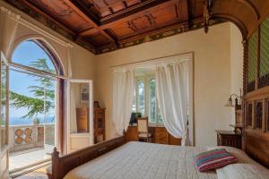 a bedroom with a large bed and a large window at Il Parco e gli Affreschi in Varese