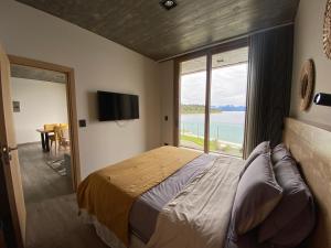 a bedroom with a large bed and a large window at Wa One Lake Homes in San Carlos de Bariloche