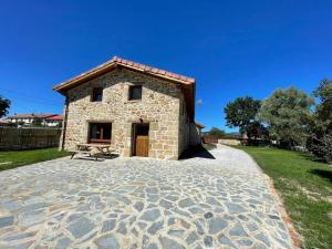 - un petit bâtiment en pierre sur une terrasse en pierre dans l'établissement Casa Rural alquiler Cantabria, 