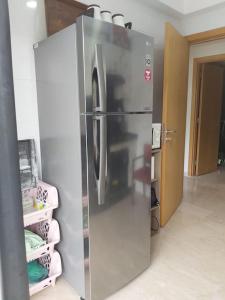 um frigorífico de aço inoxidável num quarto em Great appartement vue sur mer et piscine em Dar Bouazza