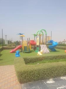 um parque com um parque infantil com escorregas e equipamento de brincar em Great appartement vue sur mer et piscine em Dar Bouazza