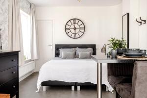 a bedroom with a bed and a clock on the wall at Beach&Dunes Studio in Zandvoort