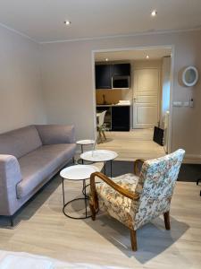a living room with a couch and a chair and tables at Rune Bergin piilopaikka in Porvoo