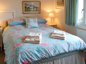 a bedroom with a bed with towels on it at Ewenny Cottage in Ewenny