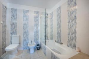 a bathroom with a toilet and a tub and a sink at Casa Da Paz in Salema +18 photos