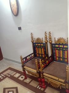 a pair of throne chairs in a room with a clock at Room with Separate Entrance & Parking & Fast Wifi in Islamabad