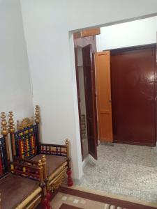 Cette chambre dispose d'un banc en bois et d'une porte. dans l'établissement Room with Separate Entrance & Parking & Fast Wifi, à Islamabad