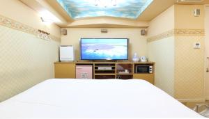 sypialnia z łóżkiem i telewizorem z płaskim ekranem w obiekcie HOTEL MINT HOUSE -resort and relaxation- w mieście Mihama +13 zdjęć