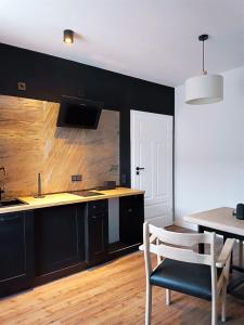 a kitchen with black cabinets and a table and chairs at Gallery Room 02 in Bielefeld