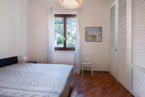 a bedroom with a bed and a window and a chair at Bilocale il Castello con parcheggio in Bonassola