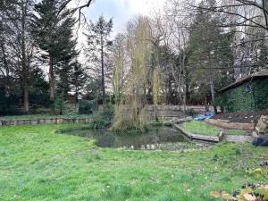 a garden with a pond in the middle of a yard at Forest Apartment gated Parking on 2 acres Garden in Chislehurst