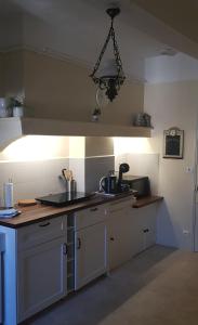 een keuken met witte kasten en een lamp bij Vista Cevenol: appartement 2 chambres in Saint-Jean-du-Gard