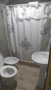 y baño con aseo, lavamanos y cortina de ducha. en madre teresa en El Nihuil