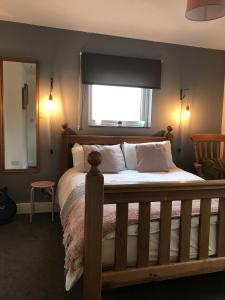 een slaapkamer met een groot bed en een raam bij Stoneleigh in Felixstowe