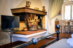 een woonkamer met een open haard en een televisie bij La casa di Olimpia in San Baronto