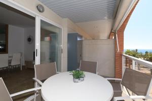 a white table and chairs on a balcony at UHC CENTER APARTMENTS in Salou